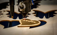 A laser engraver cutting a design on wood